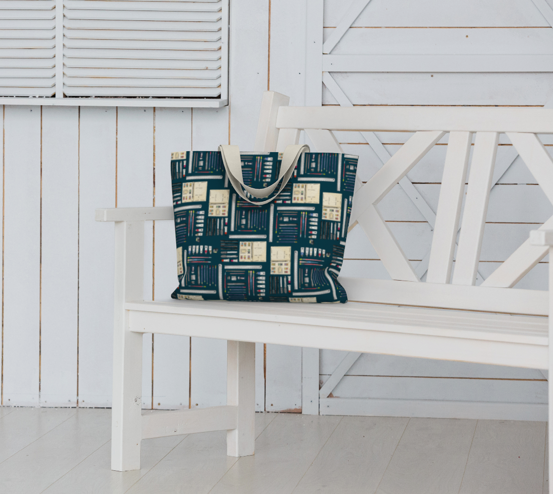 Art Supplies in a repeating pattern on a Dark Teal background. Large market tote bag with white cotton canvas handle. Bag sitting on a white garden bench seat.